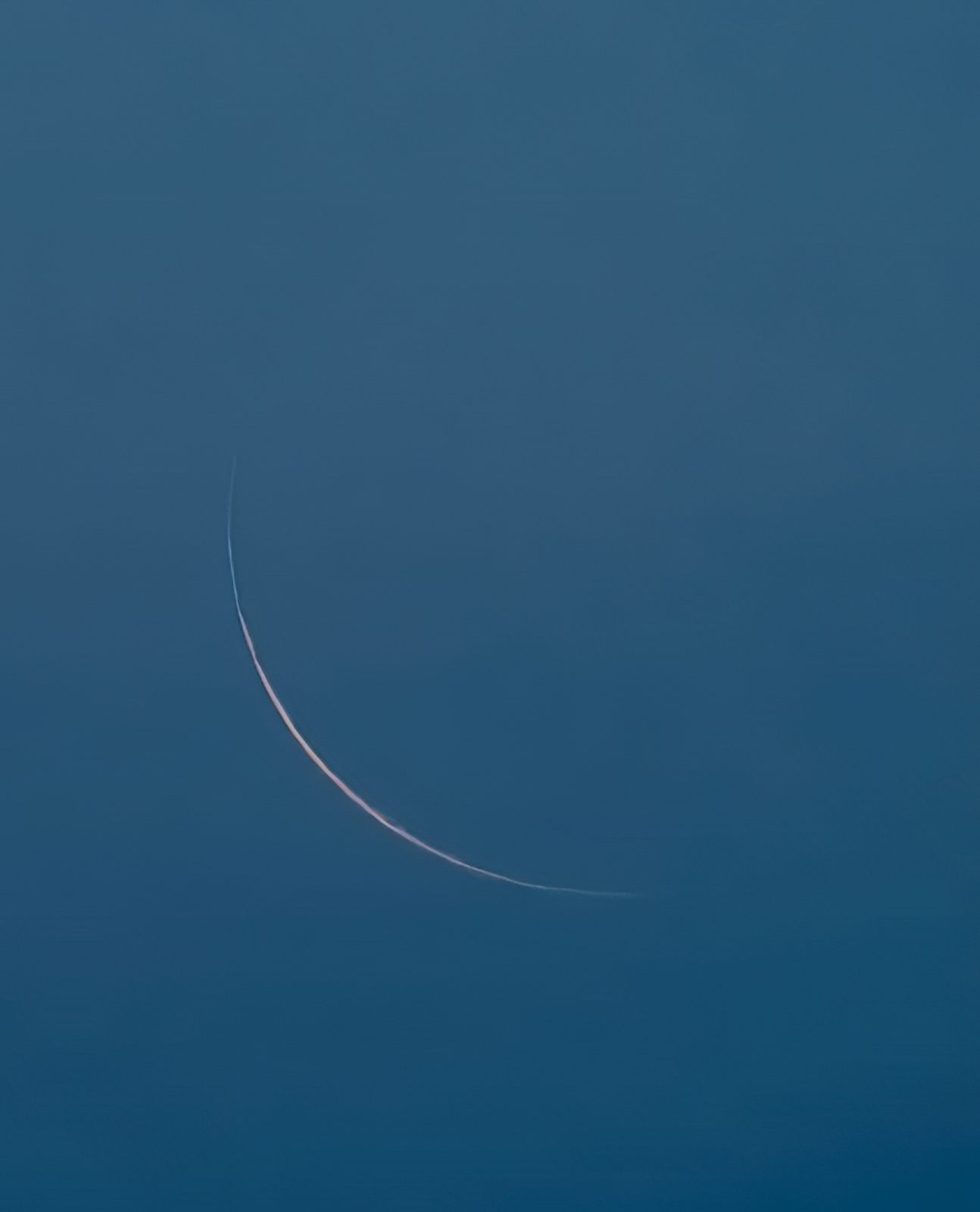 Thin crescent moon in twilight sky